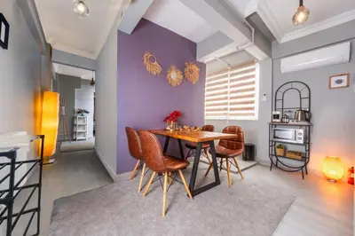 a dining room with purple walls and a wooden table and chairs at Cozy Home in Historic Istanbul in Istanbul