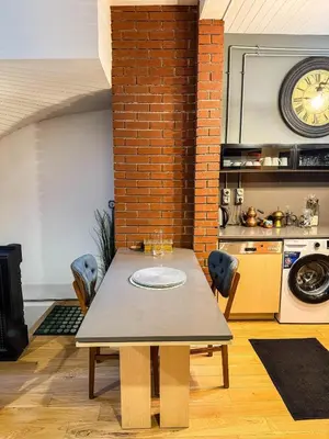 a table in a kitchen with a clock on the wall at Rent the Entire Bosphorus House in Istanbul
