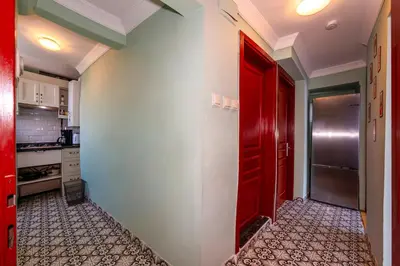 a kitchen with a red door and a refrigerator at Golden Horn Hidden Haven in Istanbul