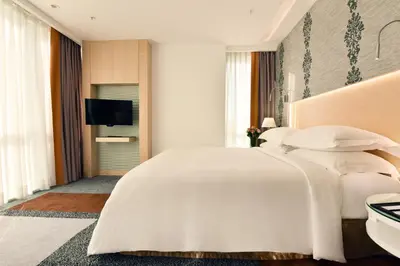 a bedroom with a large white bed and a flat screen tv at Tango Arjaan by Rotana Istanbul Asia in Istanbul