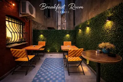 a restaurant with tables and chairs and a green hedge at Istanberry - Scarlet Three Bedroom Apartments in Istanbul