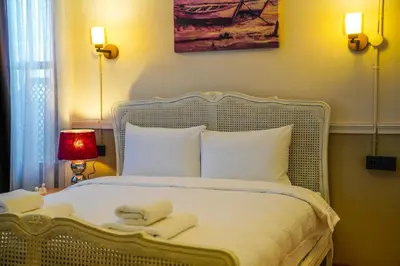 a bedroom with a white bed with two towels on it at Leila Mansion Hotel in Tekirdag