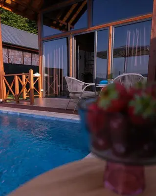 a bowl of strawberries sitting on a table next to a pool at Bell Garden Maşukiye in Kocaeli