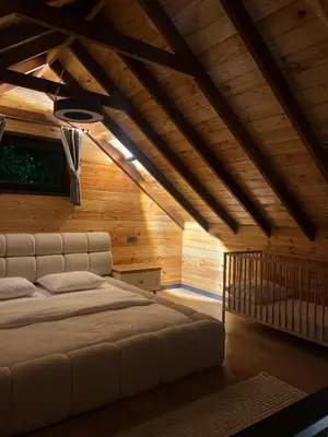 a bedroom with a white bed in a wooden ceiling at Bell Garden Maşukiye in Kocaeli