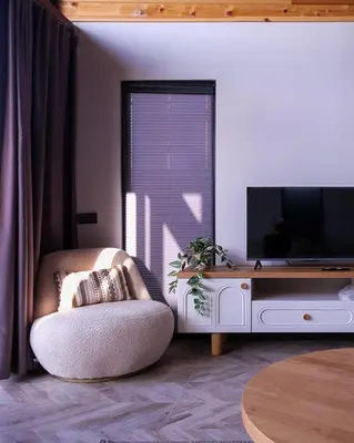 a living room with a tv and a chair at Bell Garden Maşukiye in Kocaeli