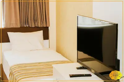 a tv sitting on a desk next to a bed at PALMYE HOTEL Beyoylu in Istanbul