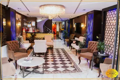 a lobby with chairs and tables and a chandelier at PALMYE HOTEL Beyoylu in Istanbul
