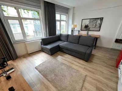 a living room with a gray couch in a room at Akaretler City View between Nişantaşı and Beşiktaş in Istanbul
