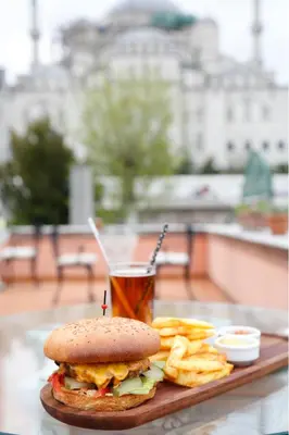 a sandwich and chips on a table with a drink at Sultanahmet Palace Hotel in Istanbul