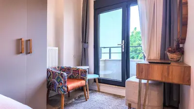 a bedroom with a window and a chair and a table at Agion Living Taksim Cihangir in Istanbul