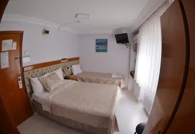 a small room with two beds and a television at Hotel Padova in Istanbul