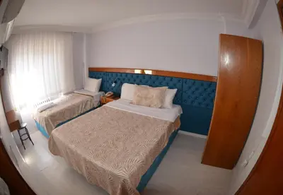 a small bedroom with two beds and a couch at Hotel Padova in Istanbul