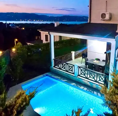 a swimming pool in front of a house at night at Ada Villam in Sapanca