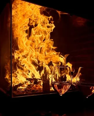 two glasses of wine in front of a fire at Ada Villam in Sapanca