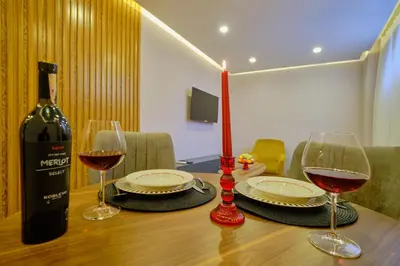 a bottle of wine and two glasses on a table at Daire 1 Jakuzili in Beylikduzu