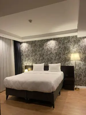 a bedroom with a large bed and a wall at Grand Armada Hotel in Avcılar