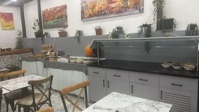 a kitchen with a counter and a table and chairs at Hotel Almina İnn in Istanbul