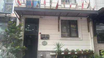 a white building with flags on a balcony at Hotel Almina İnn in Istanbul
