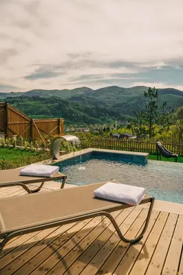 a swimming pool with two loungers on a wooden deck at Casa Vera Villa in Sakarya