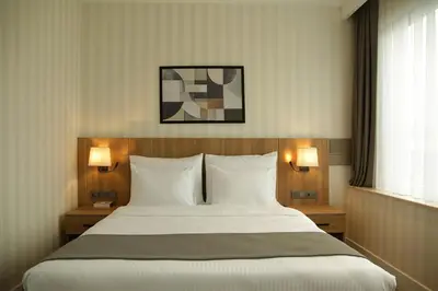 a large bed in a hotel room with two lamps at Tress Hotel in Istanbul