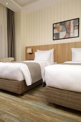 a hotel room with two beds and a chair at Tress Hotel in Istanbul