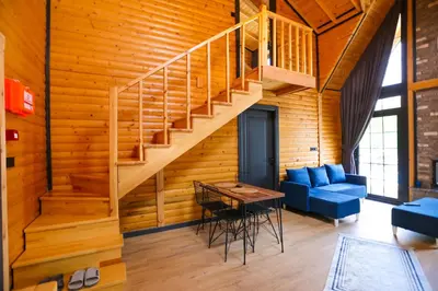 a living room with a staircase and a blue couch at MSC Bungalov Sapanca in Sapanca