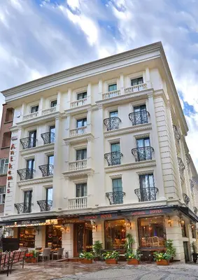 a large white building with balconies on a street at Anthemis Hotel in Istanbul