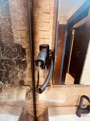 a hair dryer is attached to a wall in a bathroom at Retro, two bedroom and livingroom on Main Street in Çekmeköy