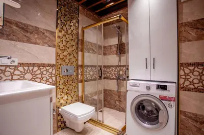 a bathroom with a toilet and a washing machine at Mutlu flat in Istanbul