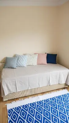 a couch in a room with blue and pink pillows at Stylish Triplex with Turkish Bath, Terrace, Central Location in Istanbul