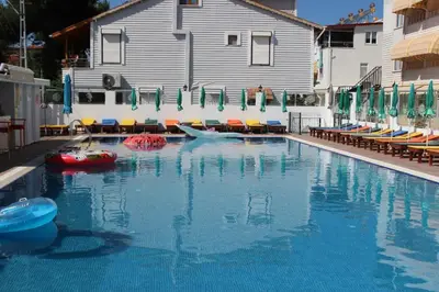 a swimming pool with two boats in the water at Aydın Motel in Marmara