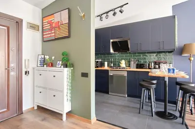 a kitchen with blue cabinets and a table with stools at Cozy Penthouse with the Balcony in Istanbul