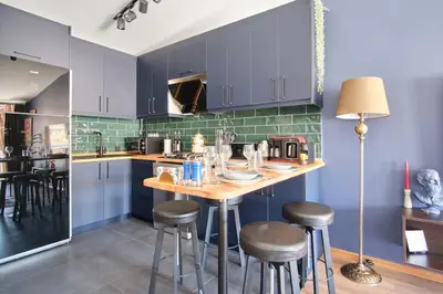 a kitchen with blue cabinets and a wooden island with stools at Cozy Penthouse with the Balcony in Istanbul