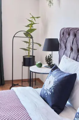a bed with a pillow and a table with a plant at Cozy Penthouse with the Balcony in Istanbul