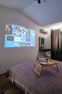 a bedroom with a bed with a table and a large screen at Cozy Penthouse with the Balcony in Istanbul