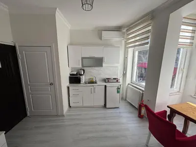 a small kitchen with white cabinets and a table at Istanberry - Scarlet Apartments in Istanbul