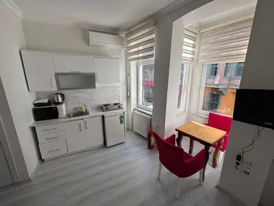 a kitchen with a table and red chairs in a room at Istanberry - Scarlet Apartments in Istanbul