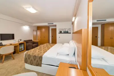 a hotel room with two beds and a desk at PALMIYE hotel SUITES in Istanbul
