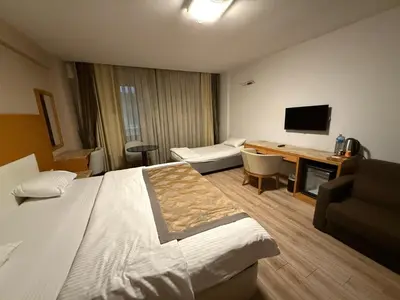 a hotel room with a bed and a couch and a desk at PALMIYE hotel SUITES in Istanbul