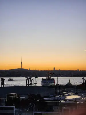 a boat on the water with the sunset in the background at Stunning 1BR w Sea View close to Galataport ! in Istanbul