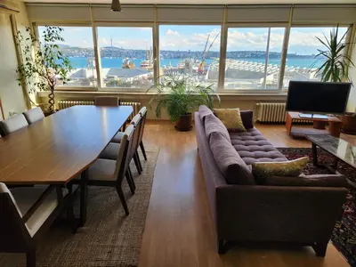 a living room with a couch and a wooden table at Stunning 1BR w Sea View close to Galataport ! in Istanbul