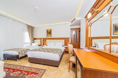 a hotel room with two beds and a desk at Hotel Spectra Sultanahmet in Istanbul