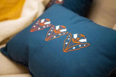 a blue pillow with orange and white flowers on it at Rum Otto Enjoy Relax 30 sec to Taksim Bathtub in Istanbul