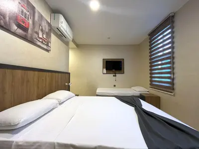 a bedroom with two beds and a flat screen tv at Valens Butik in Istanbul