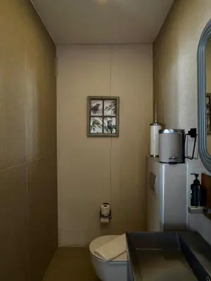 a bathroom with a white toilet and a refrigerator at Prime Suites in Kadıköy