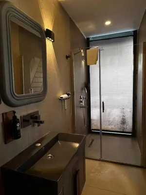 a bathroom with a sink and a shower with a window at Prime Suites in Kadıköy