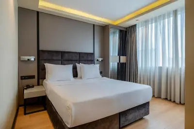 a bedroom with a large white bed and a window at Garner Hotel Istanbul - Airport Arnavutkoy by IHG in Istanbul