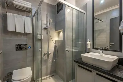 a bathroom with a shower and a sink and a toilet at Garner Hotel Istanbul - Airport Arnavutkoy by IHG in Istanbul