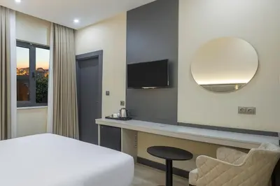 a bedroom with a bed and a desk and a mirror at Garner Hotel Istanbul - Airport Arnavutkoy by IHG in Istanbul