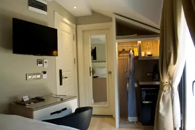 a hotel room with a bed and a desk and a closet at Barbera Hotel in Istanbul